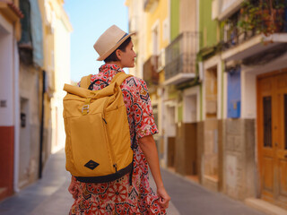Fototapeta premium Woman strolls through colorful streets of Spanish coastal town