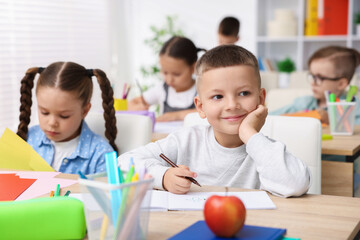 Children at wooden desk during art lesson in elementary school
