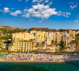 Naklejka premium Wide aerial shot of Tropea with turquoise sea, beachgoers, and picturesque cliffside homes