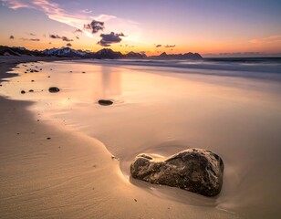 Beach scene at dusk featuring a lone rock and mountains under a pastel sky. The wet sand reflects the fading light, creating a serene atmosphere