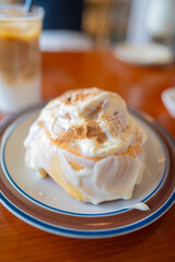 Cinnamon bun with white icing and sprinkled cinnamon