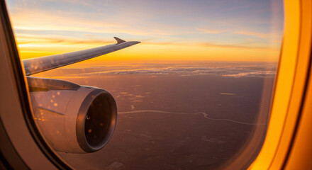 Glorious golden hour view from airplane window during sunset flight.
A stunning, high-impact photograph taken from a passenger airplane window, showcasing the dramatic colors of a sunset or sunrise