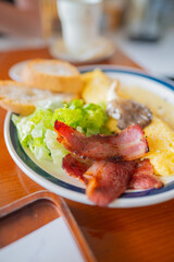 Breakfast dish with bacon scrambled eggs and lettuce