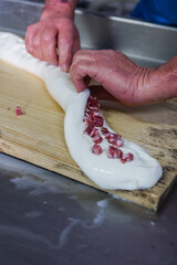 Operaio di un caseificio mentre prepara la mozzarella di bufala campana ripiena a mano 