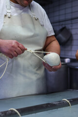 Operaio di un caseificio mentre prepara la mozzarella di bufala campana a mano 