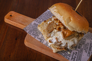 Panino da pub ripieno di funghi, hamburger di carne, provola e noci servito in un pub