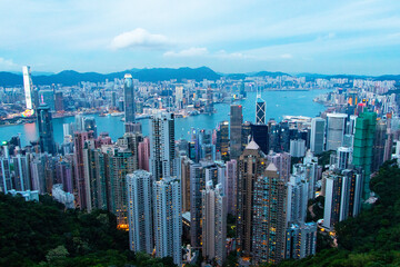Landscape of skyscraper scenery aerial view on top of buildings at night in town Hong Kong. City with bright lights at night, it's beautiful with hotels and office towers in at evening is background.
