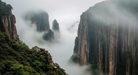 Towering, vertical rock columns shrouded in atmospheric mist, showcasing the majestic natural beauty of a Chinese mountain range.
