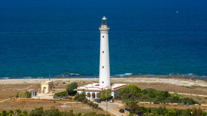 Aerial closeup of the white lighthouse of San Vito Lo Capo, on the coastline of the province of Trapani, Sicily, Italy. It is a lighthouse on the Tyrrhenian Sea coast.
