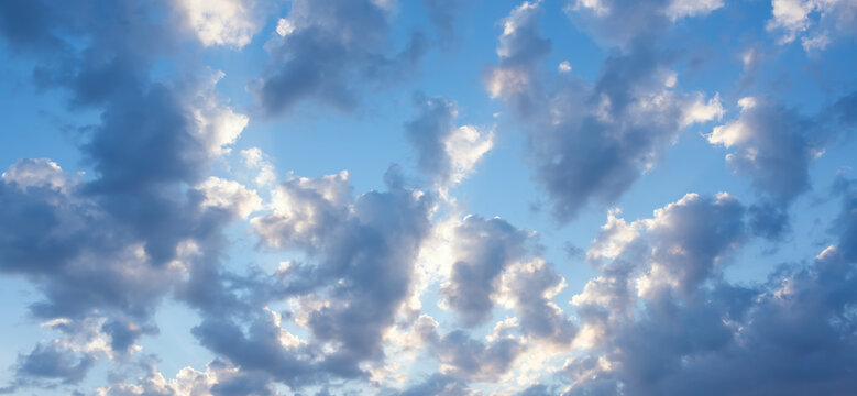 Fototapeta Sunny clear blue sky with white and gray clouds. Seasonal cloudscape. Nature background for environment, climate, and weather forecasting.