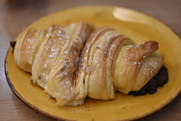 a chocolate croissant on a yellow plate
