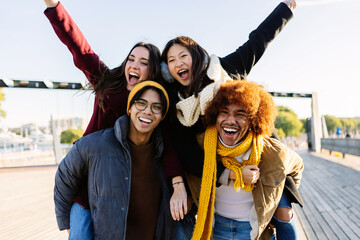 Portrait of diverse young group of friends having fun together outdoor on winter. Friendship and...
