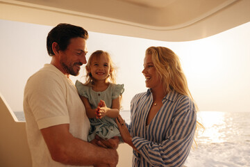 Happy family having a joyful vacation on a yacht at sunset