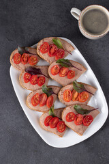 Homemade sandwiches with turkey pate and cherry tomatoes, also a cup of coffee on gray background