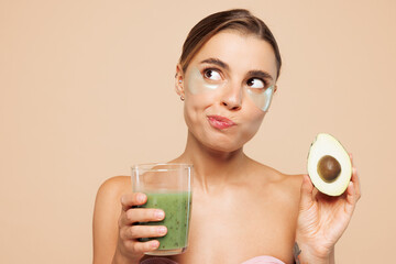 Beautiful half naked topless young woman 20s with nude make up hold avocado drink smoothie isolated...