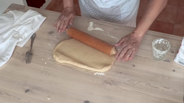 Steps of homemade wine doughnuts preparation. Dough rolled out with a wooden rolling pin. No audio.