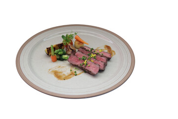 Gourmet steak dish beautifully presented on a plate, featuring perfectly cooked meat with sides