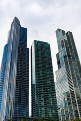 Fototapeta premium Glass building. Business city. City architecture. Modern glass building. Reflective glass architecture. Architecture in business district. Building architecture. Business building. Commercial zone