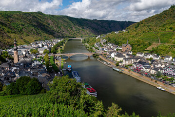 Panoramic view of the charming town along the Moselle River and its steep, terraced vineyards under a cloudy sky in Cochem, Germany