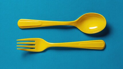 yellow spoon and yellow fork on the blue background 