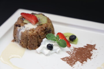A delectable dessert, artfully presented with fresh fruit, and cream, exuding a sense of culinary delight.