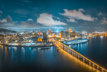 Fototapeta premium Beautiful aerial cityscape of a peninsula with casinos and hotels connected by a bridge in Macau.
