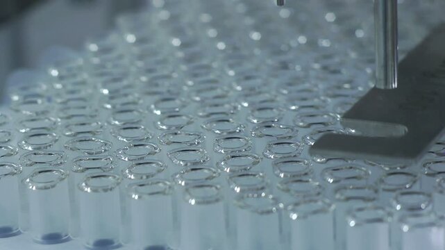 High-definition footage of an automated cleanroom assembly where glass ampoules are washed, filled with injectable medication, sterilized, and hermetically sealed. Showcases precision robotics, strict
