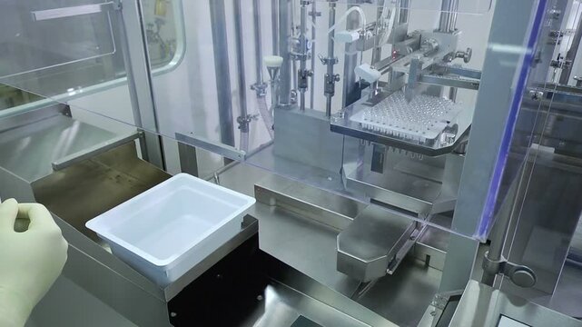 High-definition footage of an automated cleanroom assembly where glass ampoules are washed, filled with injectable medication, sterilized, and hermetically sealed. Showcases precision robotics, strict