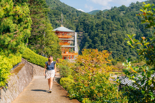 Smiling woman explores Nachi Falls and Seigantoji Temple, a beautiful Japanese cultural site