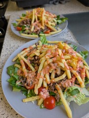 healthy homemade deconstructed burger salad with mince, fries, burger sauce, salad