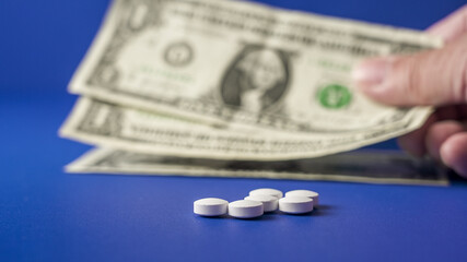 Transaction involving cash and pills on a blue background highlighting the exchange for medication