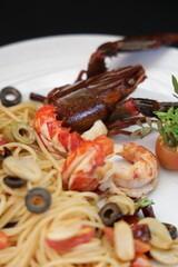 A close-up shot of a gourmet seafood pasta dish with lobster