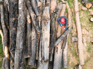 Lumberjack with a chainsaw cutting trees in the forest. Preparing firewood for winter. Top down view. Aerial view from drone
