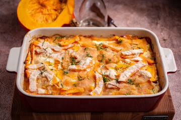 Pieces of pumpkin baked in a creamy sauce. Pumpkin baked for dinner on a brown background. Close-up