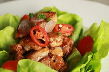 Deliciously plated chicken dish with vibrant colors and fresh ingredients, garnished on fresh lettuce leaves and ripe tomatoes, perfectly plated, ready to eat
