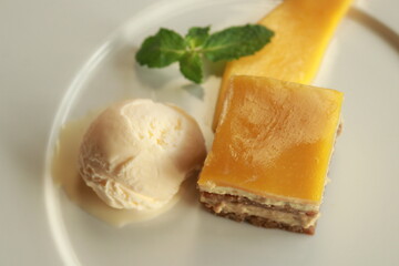 Delicious dessert featuring ice cream, a cake slice, and a mango slice