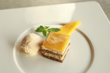 A delightful dessert composition featuring a mango pastry and ice cream on a white plate