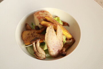 A plate of gourmet roasted vegetables arranged in a tasteful style. The dish features a variety of roasted vegetables in a contemporary style presentation 