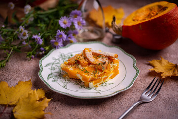 Pieces of baked pumpkin on a beautiful plate. Pumpkin baked in cream for lunch. Close-up