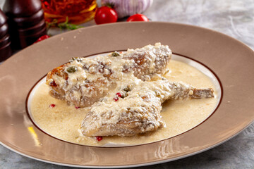 Roasted rabbit legs in cream sauce