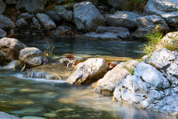 Waterfall water stream on the stones and rocks in the mountains in autumn forest