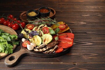 Vegetarian barbeque. Tasty grilled vegetables served on wooden table. Space for text