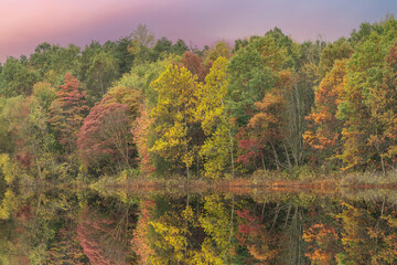 Autumn landscape at dawn of Crooked Lake with mIrrored reflections in calm water, Michigan, USA