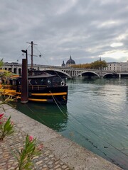 Obraz premium Rone, Lyon, France - October 22, 2025 : A black boat docked on a river Rone 