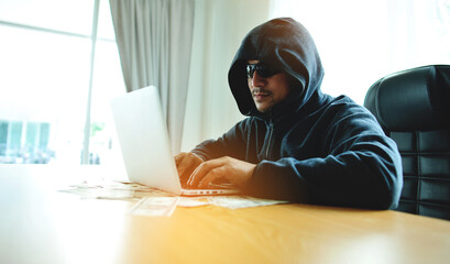 Hackers working on laptops are writing programs for hacking sensitive financial data and illegal activities.