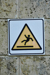 Warning slippery sign posted on the wall