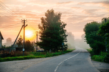 A pink sunrise over a foggy village in the Smolensk region of Russia