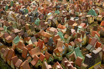 Top view of miniature ceramic houses arranged closely together outdoors. Decorative village with...