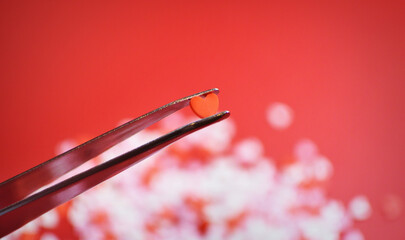 ピンセットで摘まんだハート型のトッピングシュガー　おしゃれでかわいい背景装飾　気持ち　製菓材料