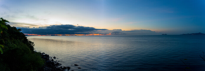 Panoramic View of Calm Sea and Distant Islands under Soft Blue Sky and Fading Sunset Light, Peaceful Coastal Landscape Concept